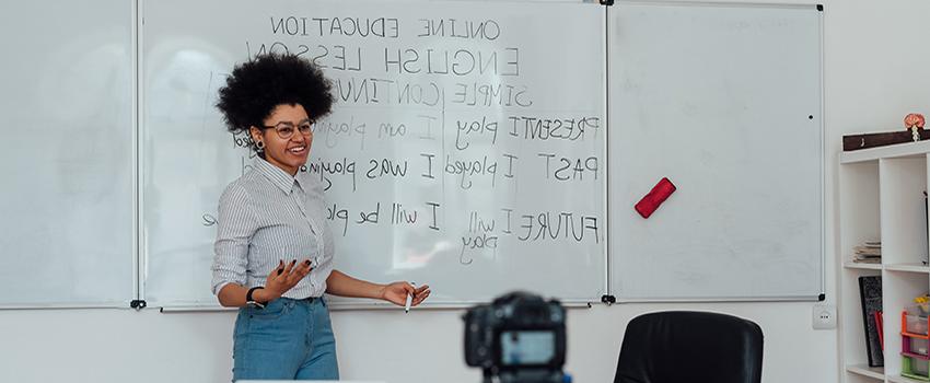 Female teaching 英语 language at white board.