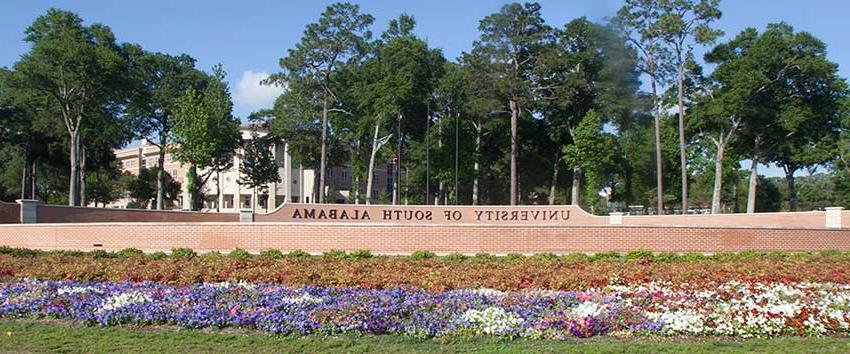 University of 南 Alabama street sign with flowers.