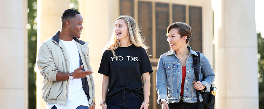 三名学生在十大彩票网投平台校园外边走边聊.
